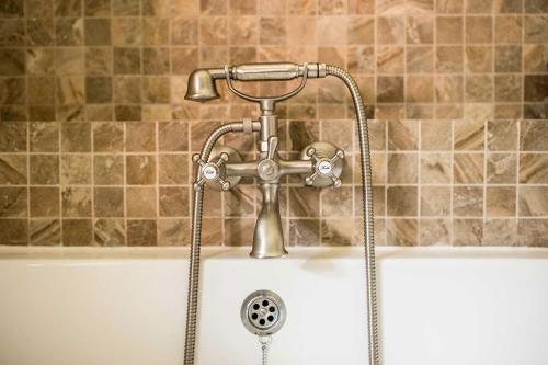 a bath tub with a faucet at Cabana Plaiul Foii in Zărneşti