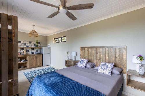 a bedroom with a bed and a ceiling fan at Pine Forest Retreat Cabin in Plettenberg Bay