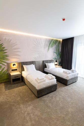 two beds in a room with two tables and avertisementvertisementvertisementvertisementvertisementvertisement at Hotel Oasis in Vinnytsya