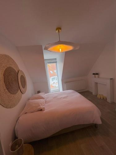 a bedroom with a white bed and a light at Maison moderne entre terre et mer in Coquelles