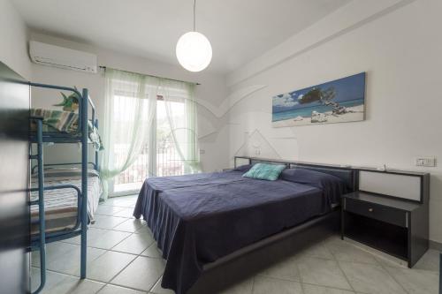 a bedroom with a bed and a window at Casa Malu in Marina di Campo
