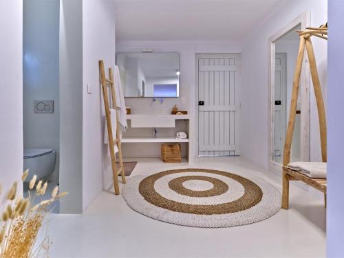 a white room with a large rug on the floor at Beach House Mikri Santa Maria in Kournonísi
