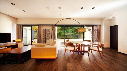 a living room with a table and a couch and a dining room at Premium Suites "Hanare Matsushimakaku" Produced by Shousuke no Yado Takinoyu in Aizuwakamatsu