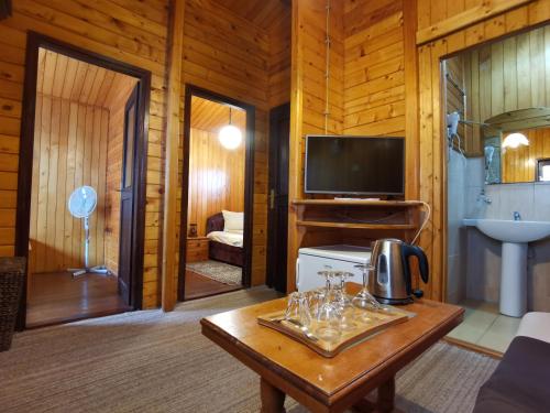 a living room with a coffee table and a television at Hotel Ravnjak in Dobrilovina