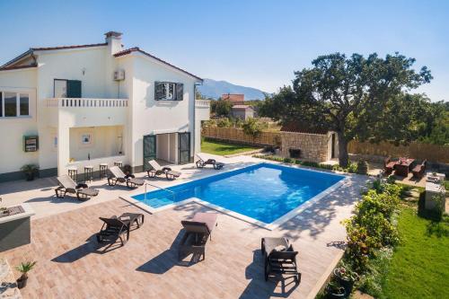a villa with a swimming pool in front of a house at Villa Mery in Šestanovac