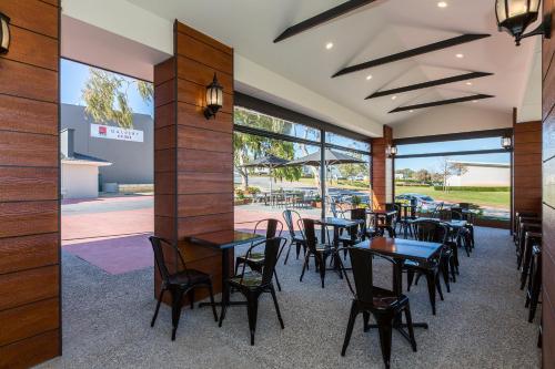 a dining room with tables and chairs in a restaurant at Gallery Hotel in Fremantle