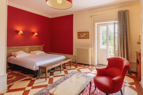 a bedroom with a bed and a red wall at Château Bellevue-Domaines Loron in Villié-Morgon