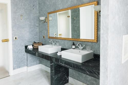a bathroom with two sinks and a mirror at Château Bellevue-Domaines Loron in Villié-Morgon