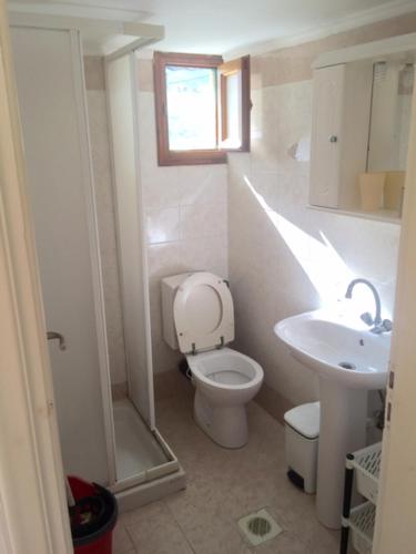 a white bathroom with a toilet and a sink at AVRA Apartments & Studios in Frý