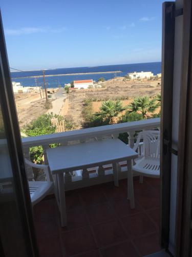 a balcony with a table and chairs and the ocean at AVRA Apartments & Studios in Frý