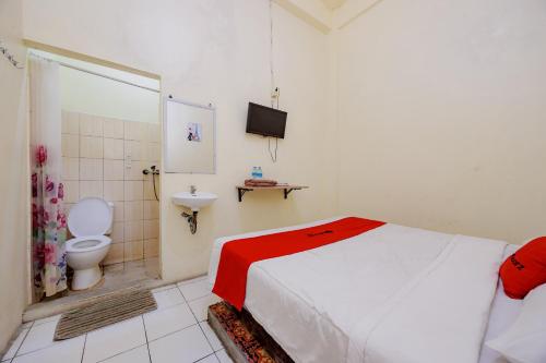 a bedroom with a bed and a toilet and a sink at RedDoorz near Soekarno Hatta Airport 3 in Tangerang