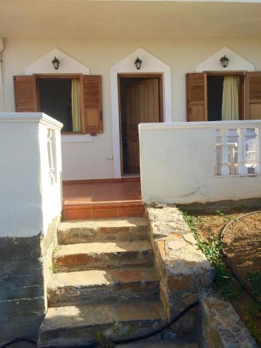 a house with some stairs in front of it at AVRA Apartments & Studios in Frý