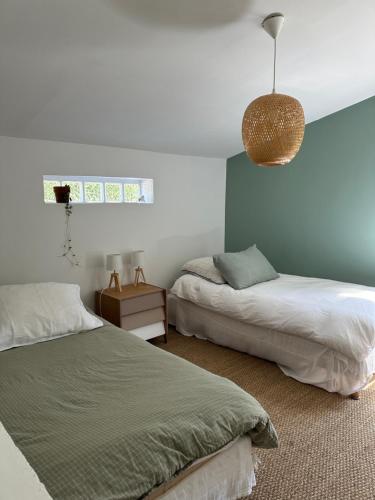 a bedroom with two beds and a pendant light at La maison de Juliette in Céret