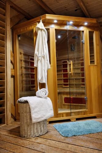 a bathroom with a shower with a wicker chair and a towel at Domki u Anitki i Nikosia in Jeleśnia