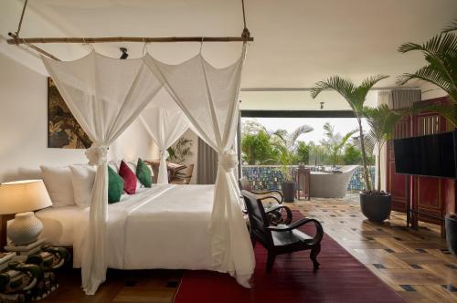 a bedroom with a white bed and a tv at aNhill Boutique in Hue
