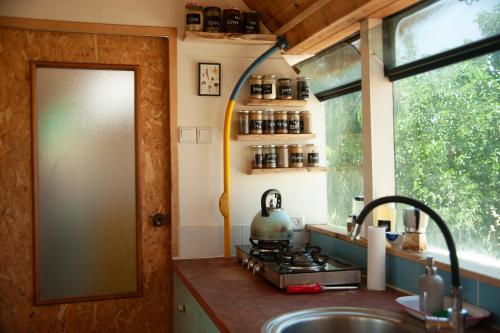 a kitchen with a sink and a stove and a window at אוטובוס בכרם in Mitzpe Ramon