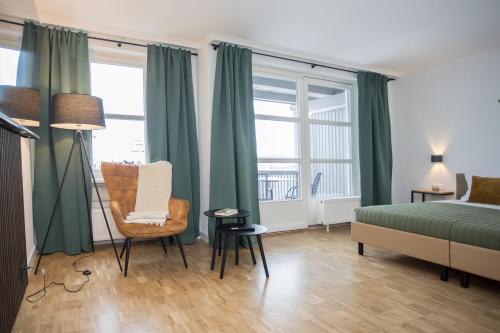 a bedroom with green curtains and a bed and a chair at UplandParcs W3 in Winterberg