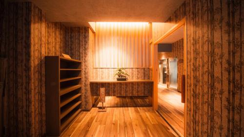 a hallway with a room with wooden floors and a shelf at Premium Suites "Hanare Matsushimakaku" Produced by Shousuke no Yado Takinoyu in Aizuwakamatsu