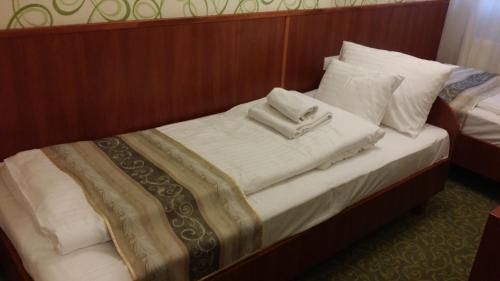 a bed with white towels on top of it at Partium Hotel Szeged in Szeged