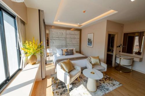 a bedroom with a bed and a couch and a table at Bestier Hotel Hatyai in Hat Yai