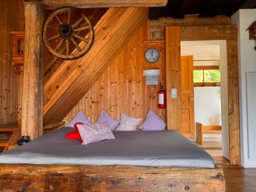 a bed in a room with a wooden wall at Ottls Huette in Sankt Lorenzen ob Murau