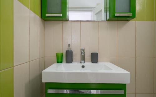a bathroom with a white sink and green cabinets at Coastal Escape - 2 min from Perissa Beach in Perissa
