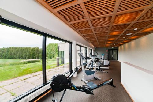 - une salle de sport avec des tapis roulants, des vélos elliptiques et des fenêtres dans l'établissement Hämeenkylän Kartano, à Vantaa