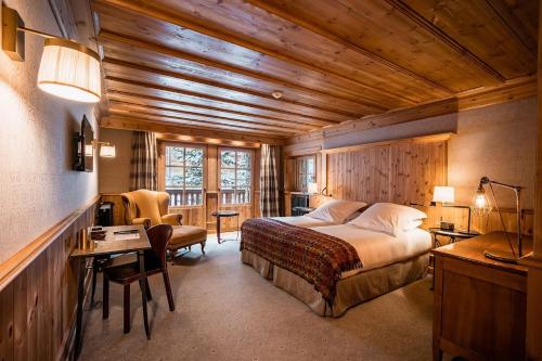a bedroom with a bed and a desk and a table sidx sidx sidx at Chalets LA MOURRA in Val-d'Isère