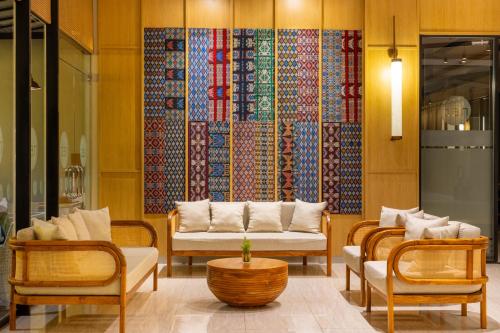 a living room with two chairs and a couch at Neo Eltari Kupang by ASTON in Kupang