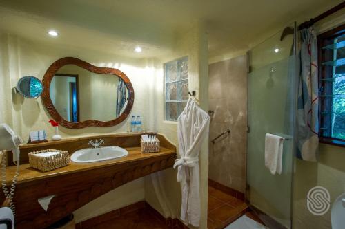 a bathroom with a sink and a mirror and a shower at Lake Manyara Serena Safari Lodge in Karatu