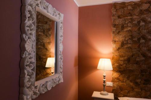 a mirror on a wall next to a lamp at Eneide in Palmi