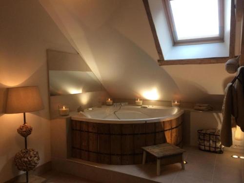 a large bathroom with a large tub with a window at Les Chambres de Ribeaufontaine in Dorengt