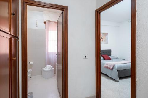 a bathroom with a mirror and a bedroom with a bed at Station House Center in Cisterna di Latina