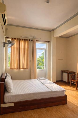 a bedroom with a large bed with a window at Candy Hotel Can Tho in Cái Răng