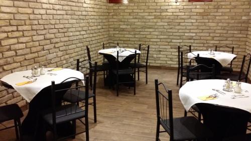 a room with tables and chairs with white table cloth at Partium Hotel Szeged in Szeged