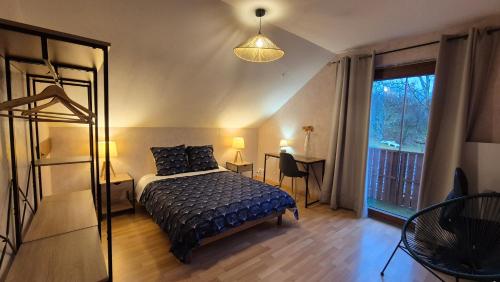 a bedroom with a bed and a large window at Les Hirondelles Chanaz in Chanaz