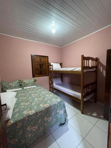 a room with two beds and two bunk beds at Casa Sonho de Verão in Ilha de Boipeba