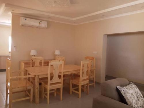 a dining room with a wooden table and chairs at 1688 BB7 Suites in Victoria Falls