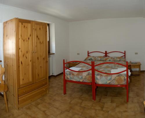 a bedroom with a bed and a wooden cabinet at Valdigiust in Campodolcino