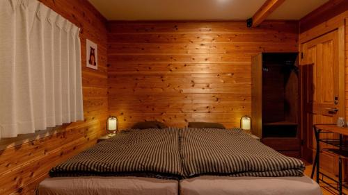a bedroom with a bed in a wooden room at Azumino Bear's Inn in Azumino