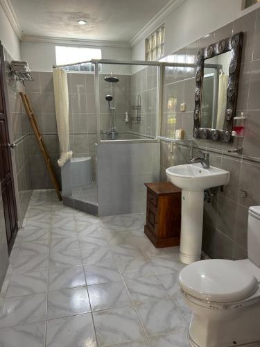 a bathroom with a toilet and a sink and a shower at Villa Pelangi - Candidasa in Candidasa