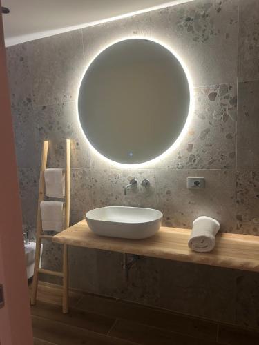 a bathroom with a sink and a large mirror at Masseria Brigarè in Cassano delle Murge