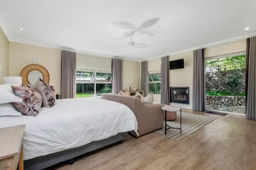 a bedroom with a large white bed and a couch at Manor On Main in Midrand