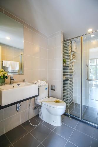 a bathroom with a toilet and a sink and a shower at Vista Residence Old Town in Phuket
