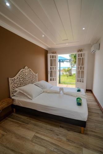 a bedroom with a large bed and a window at La Villa Bleue, Pieds dans l'eau in Saint-Leu