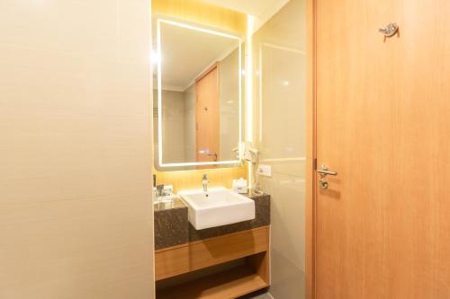 a bathroom with a sink and a mirror at Metland Hotel Cirebon by Horison in Cirebon