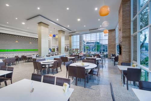 a restaurant with tables and chairs and windows at Kaewsamui Resort in Ban Tha Phet Noi