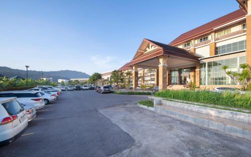 a parking lot with cars parked in front of a building at Kaewsamui Resort in Ban Tha Phet Noi