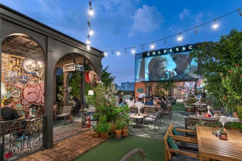 a patio at a restaurant with people sitting at tables at Quartier by Montraj Sukhumvit Bangkok in Bangkok