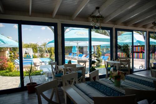 a restaurant with tables and chairs and a view of a pool at Casa din Delta in Murighiol